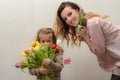 Little girl child, daughter gives mom a bouquet of flowers of colorful tulips - happy family Royalty Free Stock Photo