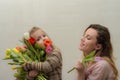 Little girl child, daughter gives mom a bouquet of flowers of colorful tulips - happy family Royalty Free Stock Photo