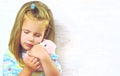 Little girl child hugs toy bear closed eyes