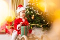 Little girl child makes a wish and dreams near Christmas tree Royalty Free Stock Photo