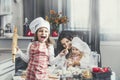 Little girl child with mother and sister happy cook at the table