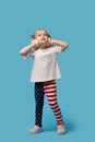 Little girl child in patriotic american pants jumping for joy on a blue Royalty Free Stock Photo