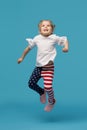 Little girl child in patriotic american pants jumping for joy on a blue Royalty Free Stock Photo