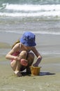 Little girl child playing with the sand in the sea Royalty Free Stock Photo