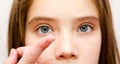 Little girl child putting contact lens into her eye closeup Royalty Free Stock Photo