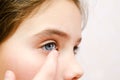 Little girl child putting contact lens into her eye closeup Royalty Free Stock Photo