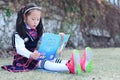 Little girl Child reading a book on the grass Royalty Free Stock Photo