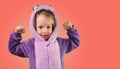 little girl child shows strong strength tensing muscles in purple pajamas