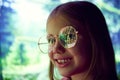 Little girl, child standing outdoors with happy smiling face and looking on lights. Christmas tree reflection on kid Royalty Free Stock Photo