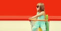 Little girl child with trolley cart and shopping bags on city street Royalty Free Stock Photo