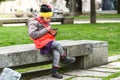 Little girl child using a mobile phone in public park. Royalty Free Stock Photo