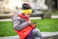 Little girl child using a mobile phone in public park. Royalty Free Stock Photo