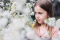 Little girl child in a white flower garden holding a tiny bunch of yellow flowers in her hands Royalty Free Stock Photo