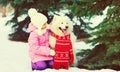 Little girl child with white Samoyed dog wearing scarf walking in winter park Royalty Free Stock Photo