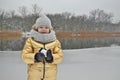 Little girl child in winter sculpts a snowman from the snow.