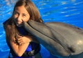 Little girl children kissing a gorgeous dolphin flipper smiling face happy kid swim bottle nose dolphins