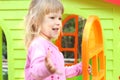 Little girl with a children's playhouse