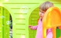 Little girl with a children's playhouse