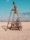 Little girl chilling resting in beach chair Happy child smiling relaxing enjoying life sun fresh air. Autumn travel Royalty Free Stock Photo