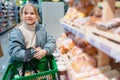 a little girl chooses sweet pastries on the counter in the store. Royalty Free Stock Photo