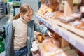 a little girl chooses sweet pastries on the counter in the store. Royalty Free Stock Photo