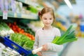 Little girl choosing a leek in a food store Royalty Free Stock Photo