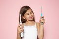 Little girl choosing between manual and electric toothbrushes