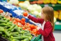 Little girl choosing tomatoes in a food store Royalty Free Stock Photo