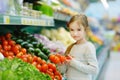 Little girl choosing tomatoes in a food store Royalty Free Stock Photo