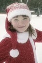 Little girl in Christmas dress in snowfall Royalty Free Stock Photo