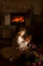 Little girl with Christmas gift in the night dark room