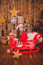 Little girl in Christmas pajamas and Santa hat in Christmas background