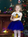 A little girl in the Christmas Studio. A little girl with blond hair smiles and holds a toy in her hands Royalty Free Stock Photo