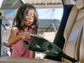 Little girl cleaning a car using a portable handheld vacuum cleaner