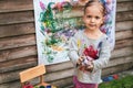 Little girl cleans brush with a rag after painting