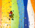 Little Girl Climbing Rock Wall practical wall in gym Royalty Free Stock Photo