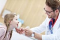 Little girl in clinic having a checkup with laryngologist