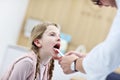 Little girl in clinic having a checkup with laryngologist