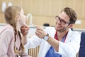 Little girl in clinic having a checkup with laryngologist