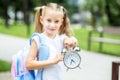 Little girl with a clock. The concept of school, study, education, friendship, childhood. Royalty Free Stock Photo