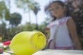 Little girl close to lub, juggling clubs in the park