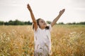 Little Girl closed her eyes and raised her hands to the sky.praying in a field wheat