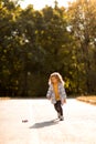 Little girl in coat in autumn plays with toy car on remote control in Park Royalty Free Stock Photo