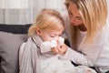 Little girl with cold and blowing her nose Royalty Free Stock Photo