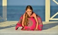 Little girl in colorful dress on the wooden pier near the ocean. Royalty Free Stock Photo