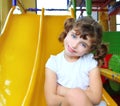 Little girl in colorful playground yellow slide