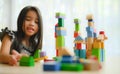 Little girl in a colorful shirt playing with construction toy blocks building a tower . Kids playing. Children at day care. Child