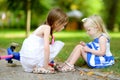 Little girl comforting her sister after she fell while riding her scooter Royalty Free Stock Photo