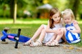 Little girl comforting her sister after she fell while riding her scooter Royalty Free Stock Photo