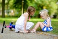 Little girl comforting her sister after she fell while riding her scooter Royalty Free Stock Photo